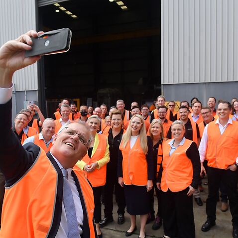 Prime Minister Scott Morrison takes a selfie with workers at an engineering facility specialising in renewable technology during a visit to the Hunter Valley, Monday, November 8, 2021