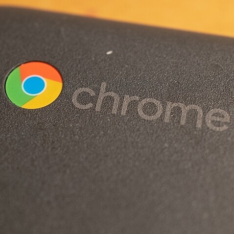 Close-up of logo for Google Chrome on the corner of a compact Google Chromebook laptop on a light wooden desk surface, San Ramon, California, August 22, 2019. 