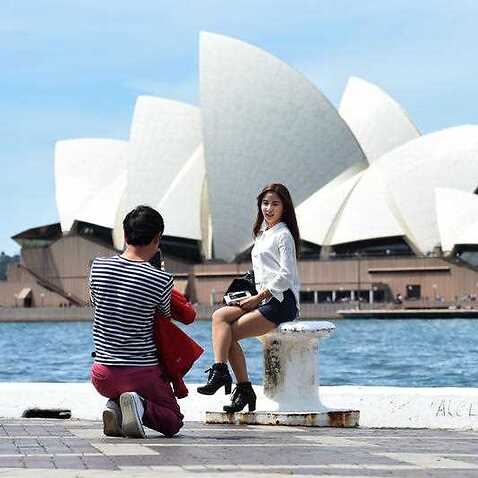 Asian tourists take in the sites of the Sydney Harbour Bridge and the Sydney Opera House.