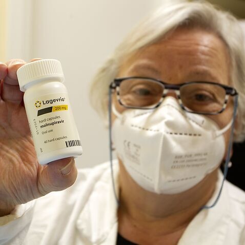 : Doctor shows the bottle of Lagevrio pills, Molnupiravir
