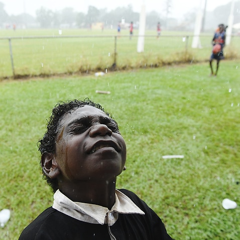 'It Always Rains Before Kick Off' captures a young football fan feeling the rain on his face minutes before kick-off for the Tiwi Islands grand final.