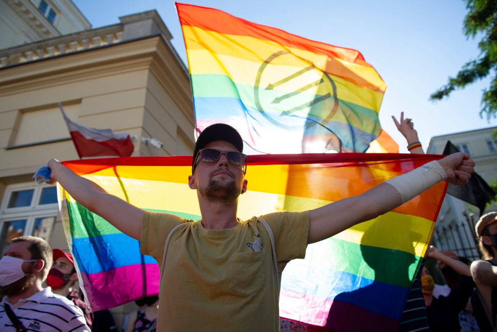 A demonstrator holds an LGBTIQ+ flag during the protest. 