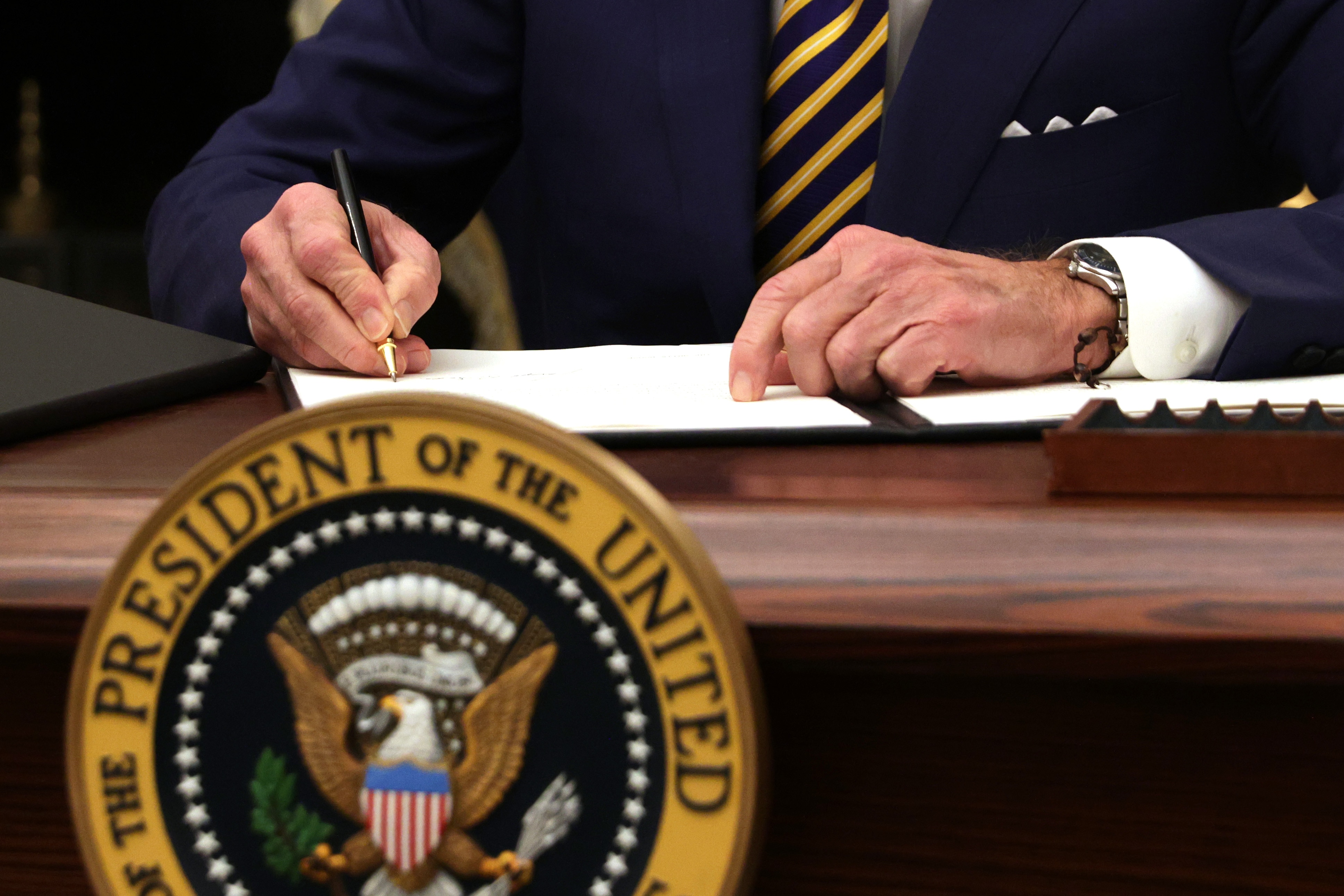 US President Joe Biden signs an executive order during an event  at the White House on 22 January, 2021.