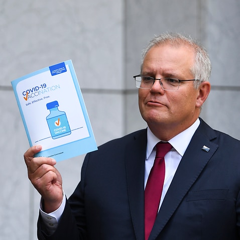 Australian Prime Minister Scott Morrison holds up a COVID19 vaccination leaflet as speaks to the media during a press conference at Parliament House in Canberra, Thursday, February 4, 2021. (AAP Image/Lukas Coch) NO ARCHIVING