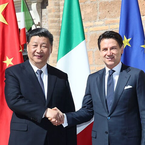 Chinese President Xi Jinping and Italian Prime Minister Giuseppe Conte shake hands in Rome, Italy. 