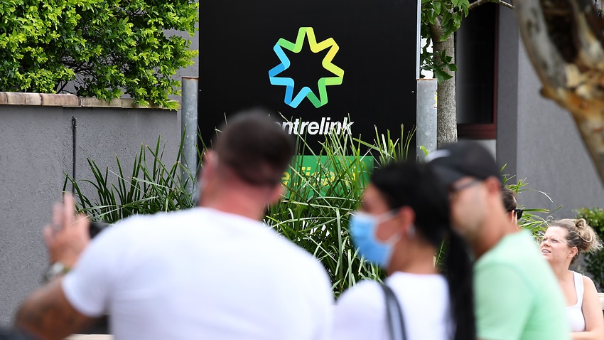 People are seen in long queues outside the Centrelink office in Southport on the Gold Coast, Monday, March 23, 2020. Centrelink offices around Australia have been inundated with people attempting to register for the Jobseeker allowance in the wake of busi