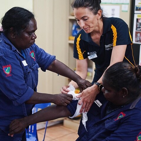 Care Flight nurse Jayne Sheppard (centre) teaches Thamarrurr Rangers how to tourniquet (SBS)