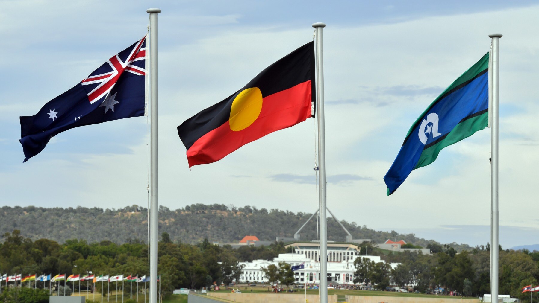 As três bandeiras australianas juntas, reconhecendo as distinções entre os três povos: não-Indígenas, Aborígenes e Ilhéus do Estreito de Torres