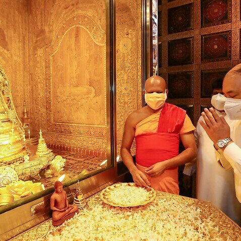Indias Foreign Secretary Harsh Vardhan Shringla (R) pays respects at the Sri Lankas holiest Buddhist shrine 'Temple of the Tooth' during his official visit in Kandy on October 3, 2021