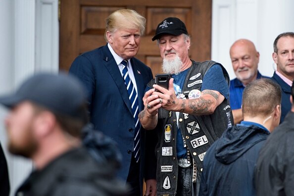 US President Donald Trump takes a selfie with a supporter during a Bikers for Trump.