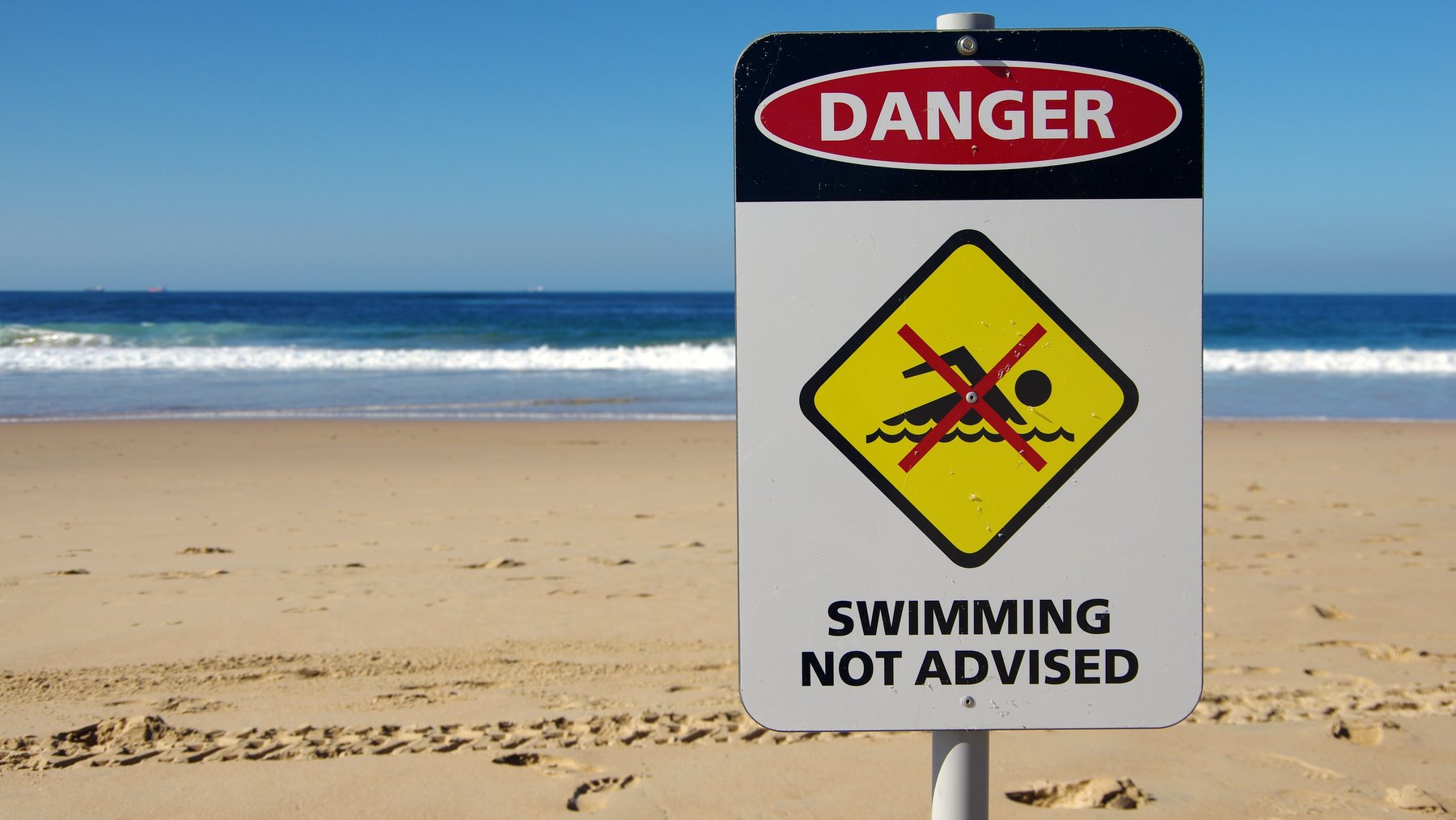 'Danger: swimming not advised' sign on North Wollongong Beach, New South Wales, Australia