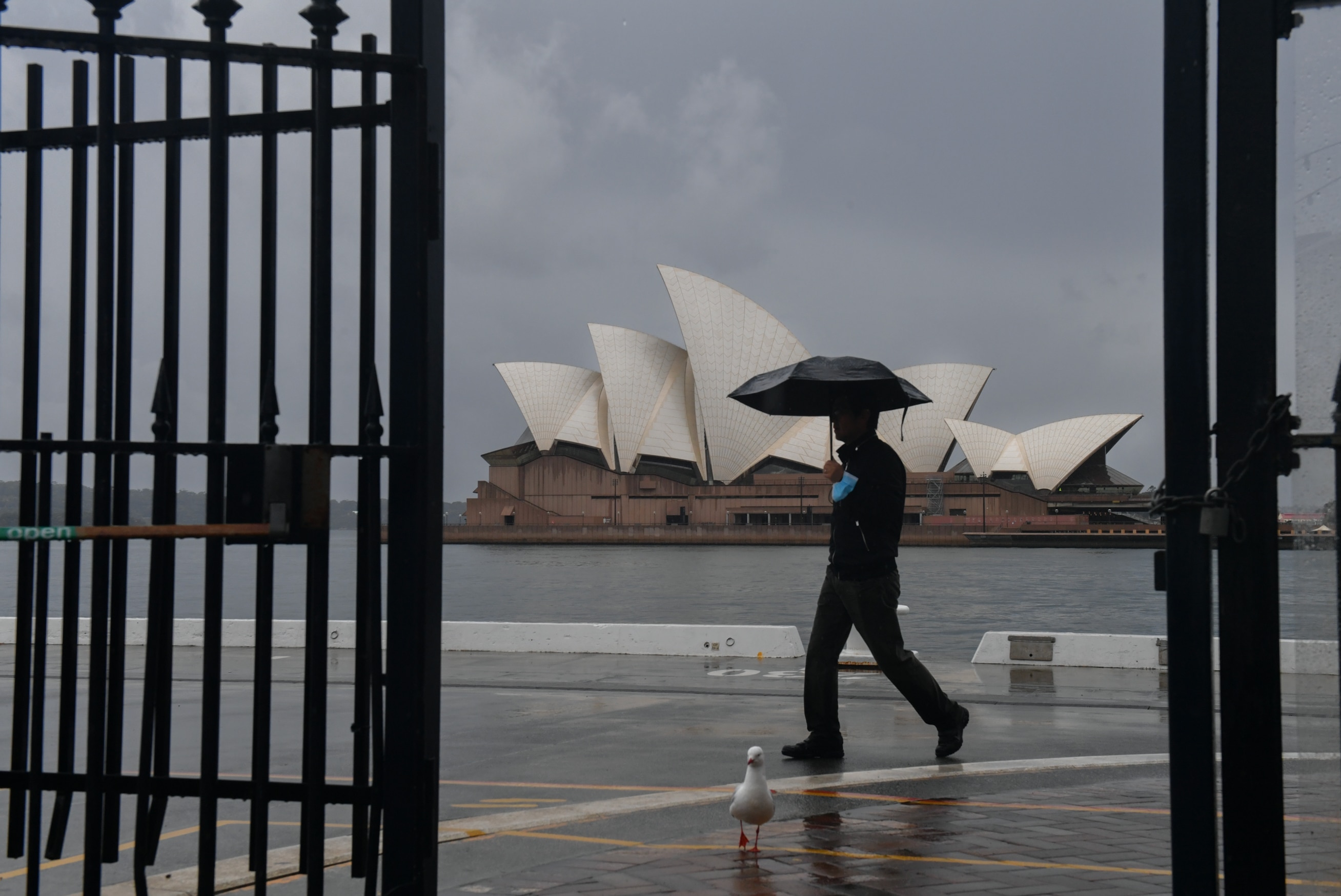 A pedestrian walks past a deserted Sydney Opera House during the city's lockdown.