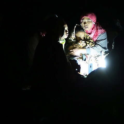 A mother holds her son during aftershocks at Duman village in Lombok, West Nusa Tenggara, Indonesia