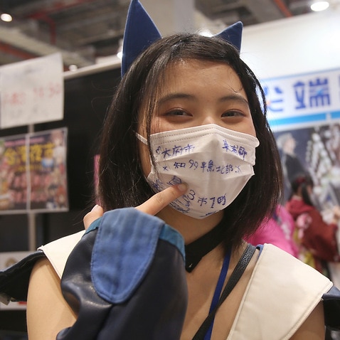 An attendee of the Comic Exhibition in Taipei in Taiwan wears a face mask. 