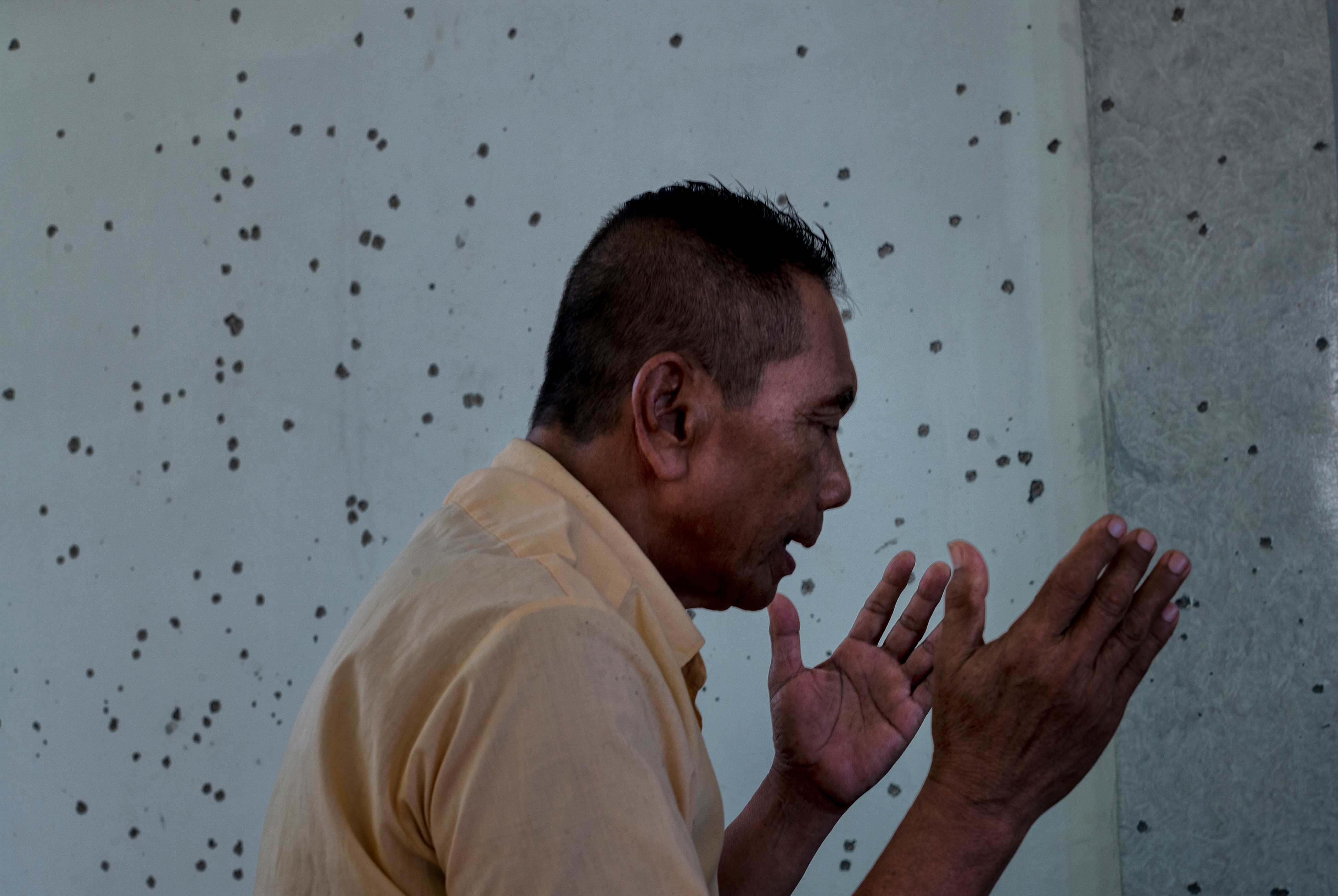 Laurel Julsali prays inside a mosque that has been hit with grenades, in Talon-Talon, Philippines.