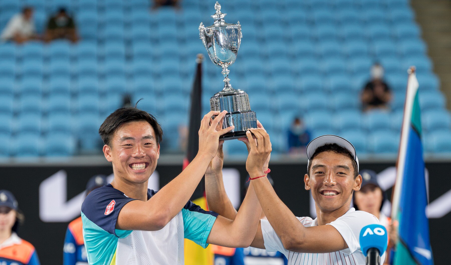 Chak Lam Coleman Wong of Hong Kong (L) and Bruno Kuzuhara of United States pose with the champions trophy 