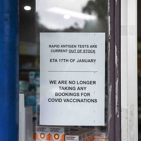 Signage notifying customers that Rapid Antigen Test kits are sold out is seen on the entrance to a chemist in Sydney.