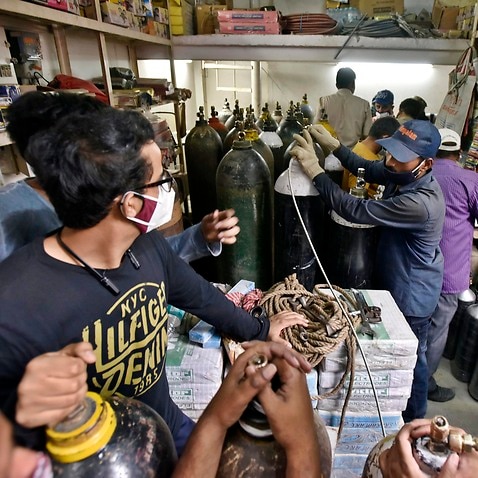 People wait to refill empty oxygen cylinders at Bhogal Jangpura in New Delhi, India, on 2 May, 2021. 
