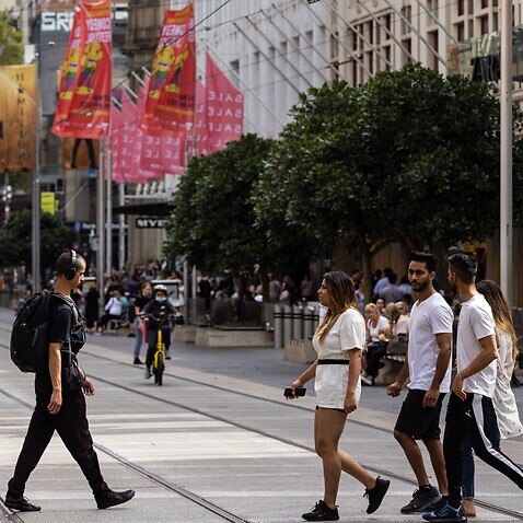People cross Bourke Street Mall in Melbourne, Sunday, March 20, 2022. (AAP Image/Diego Fedele) NO ARCHIVING