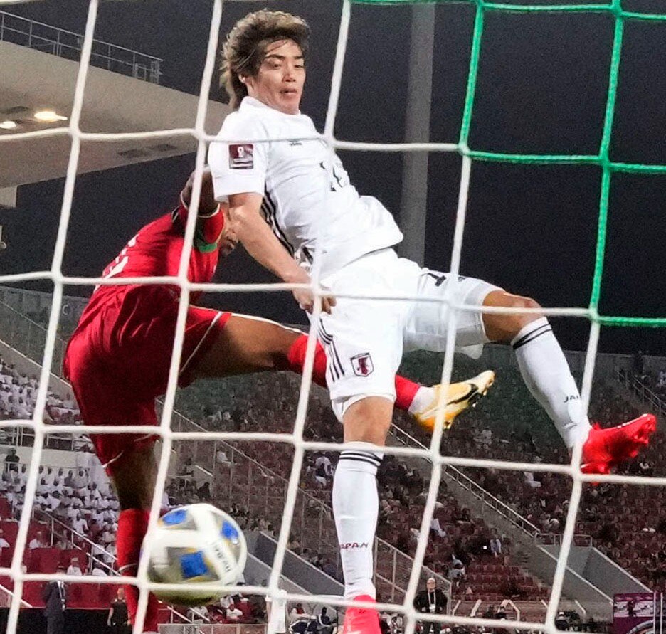 Junya Ito of Japan (R) scores a goal during the second half of a Group B football match against Oman on Nov. 16, 2021, at Muscat's Sultan Qaboos Stadium in the final group-phase round of Asian qualifying for the 2022 World Cup in Qatar. 