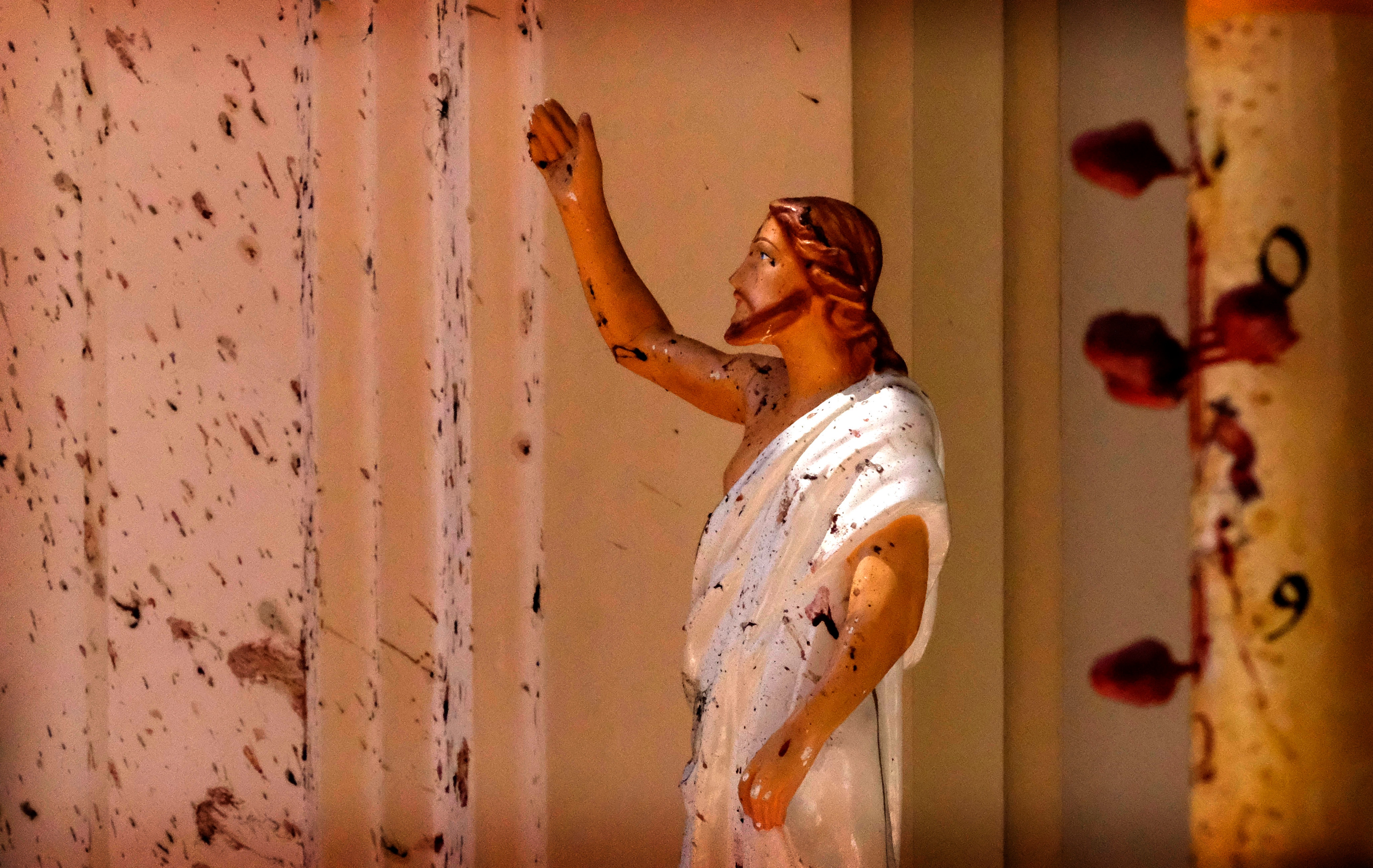Blood stains are seen on the wall and on a Jesus Christ statue at the St Sebastian's Church after blast in Negombo, north of Colombo, Sri Lanka.