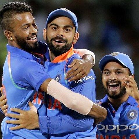 Indian cricket player Hardik Pandya, left celebrates with captain Virat Kohli, center and Kedar Jadhav after taking Steven Smith's wicket. (AAP Image/AP Photo/Rajanish Kakade)