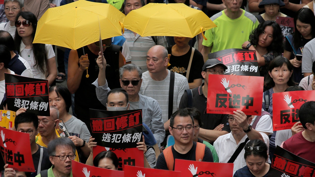Thousands of protesters march along a downtown street to against the extradition law in Hong Kong.