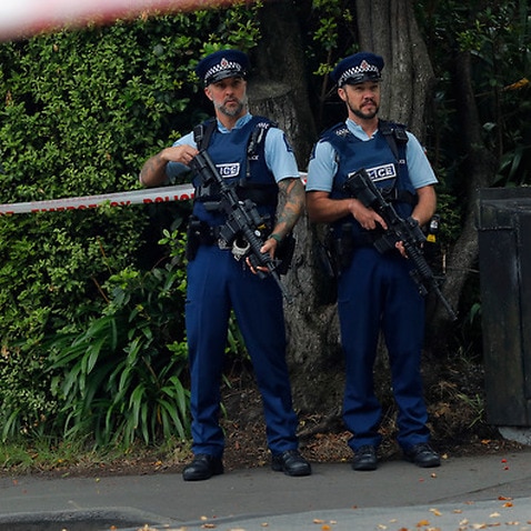 Armed police officers stand guard outside the Masjid Al Noor mosque in Christchurch