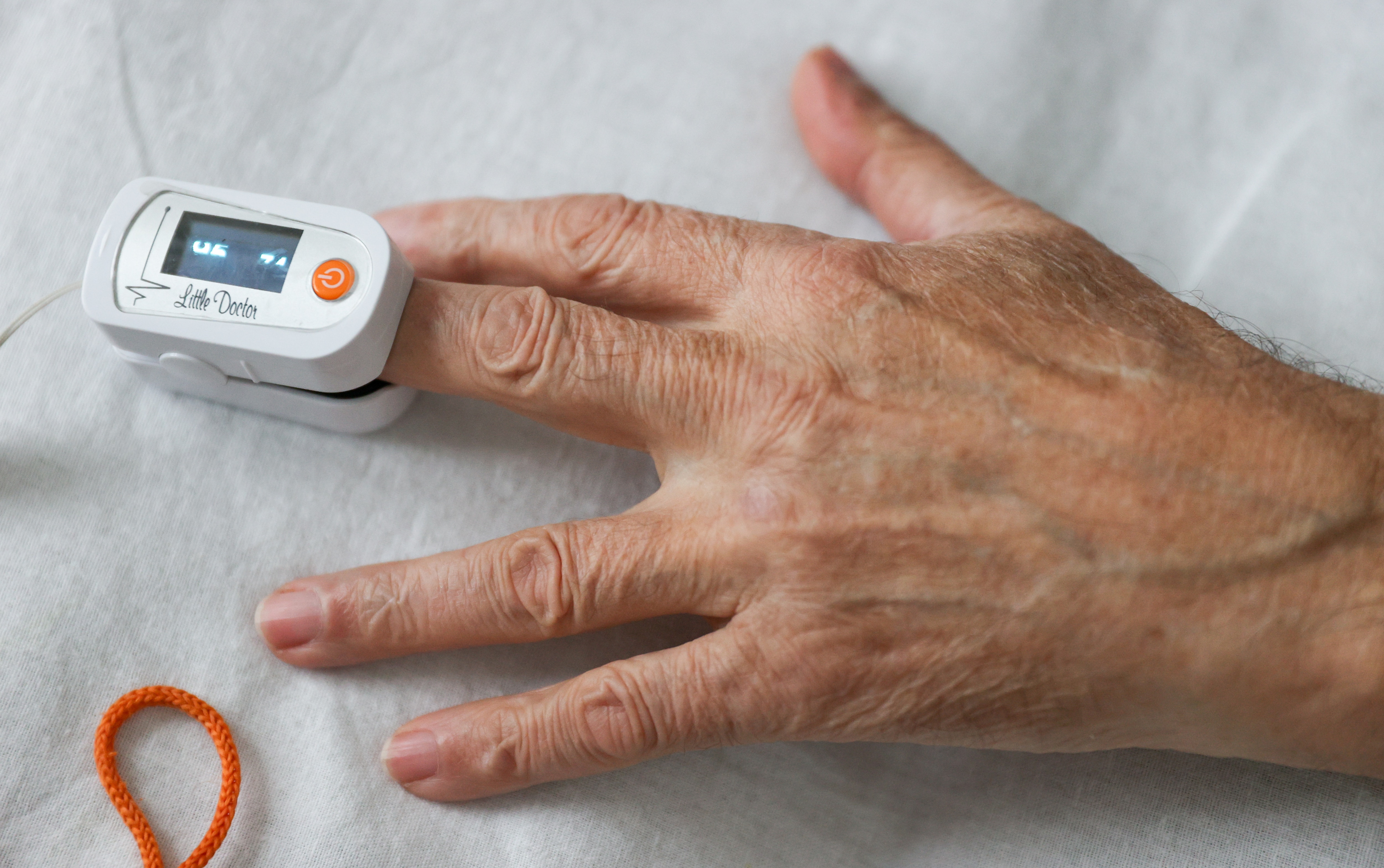 A hospital patient with a pulse oximeter on their finger.