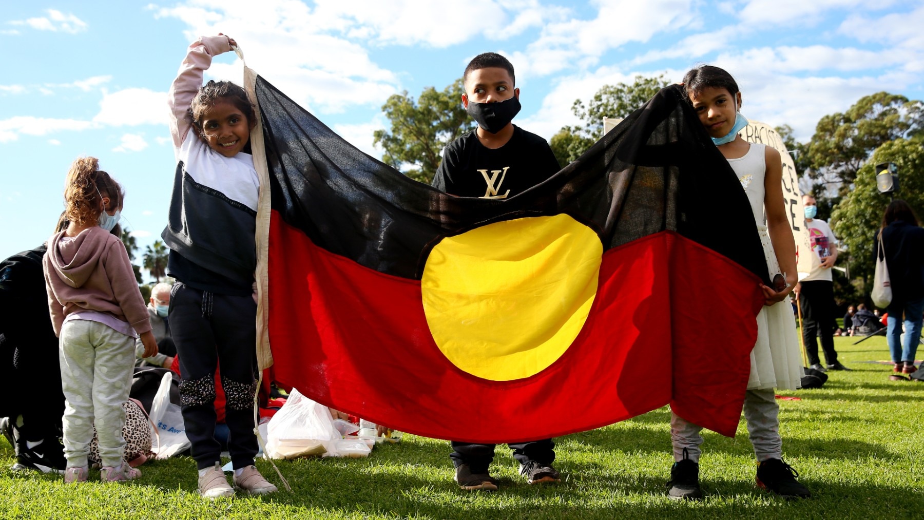 Children hold Aboriginal flag