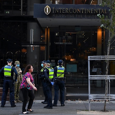 Victorian Police officers and Australian Defence personnel stand outside the Intercontinental hotel quarantine facility in Melbourne on 8 April 2021. 