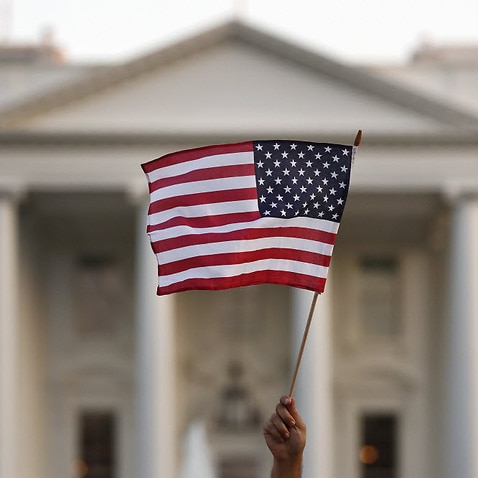 A US flag is waved during an immigration rally outside the White House, in Washington, Sept. 2017