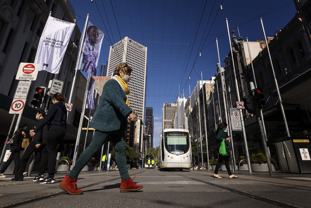People are seen crossing Bourke Street Mall in Melbourne.