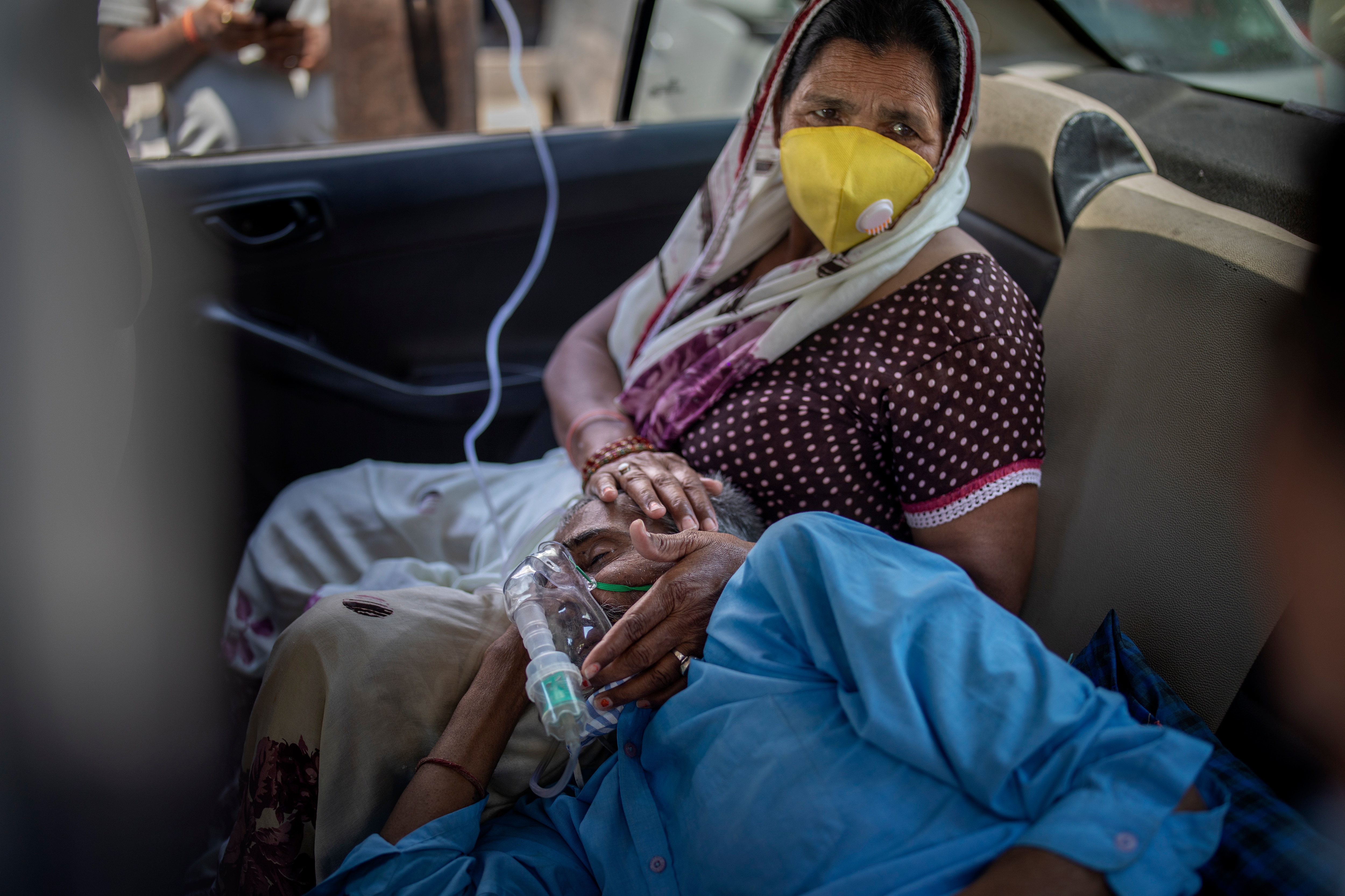 A patient breathes with the help of oxygen provided by a Gurdwara, Sikh place of worship, inside a car in New Delhi, India.