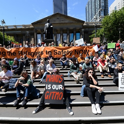 Protesters rally with the Refugee Action Collective outside the Victorian state library.