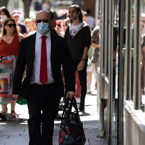 A file image of a man walking down Elizabeth Street in Melbourne.