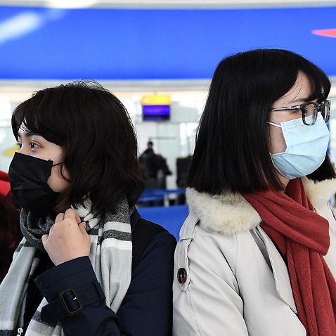People wearing face masks arrive at Heathrow Airport in London