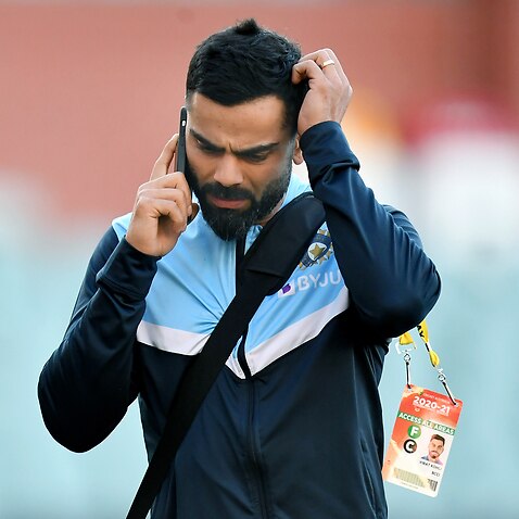 Indian captain Virat Kohli reacts during a telephone call as he leaves the stadium following Australinas victory on day 3 of the first Test Match