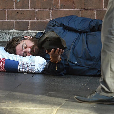 A homeless man holds out his cap for money in Sydney's Central Business District