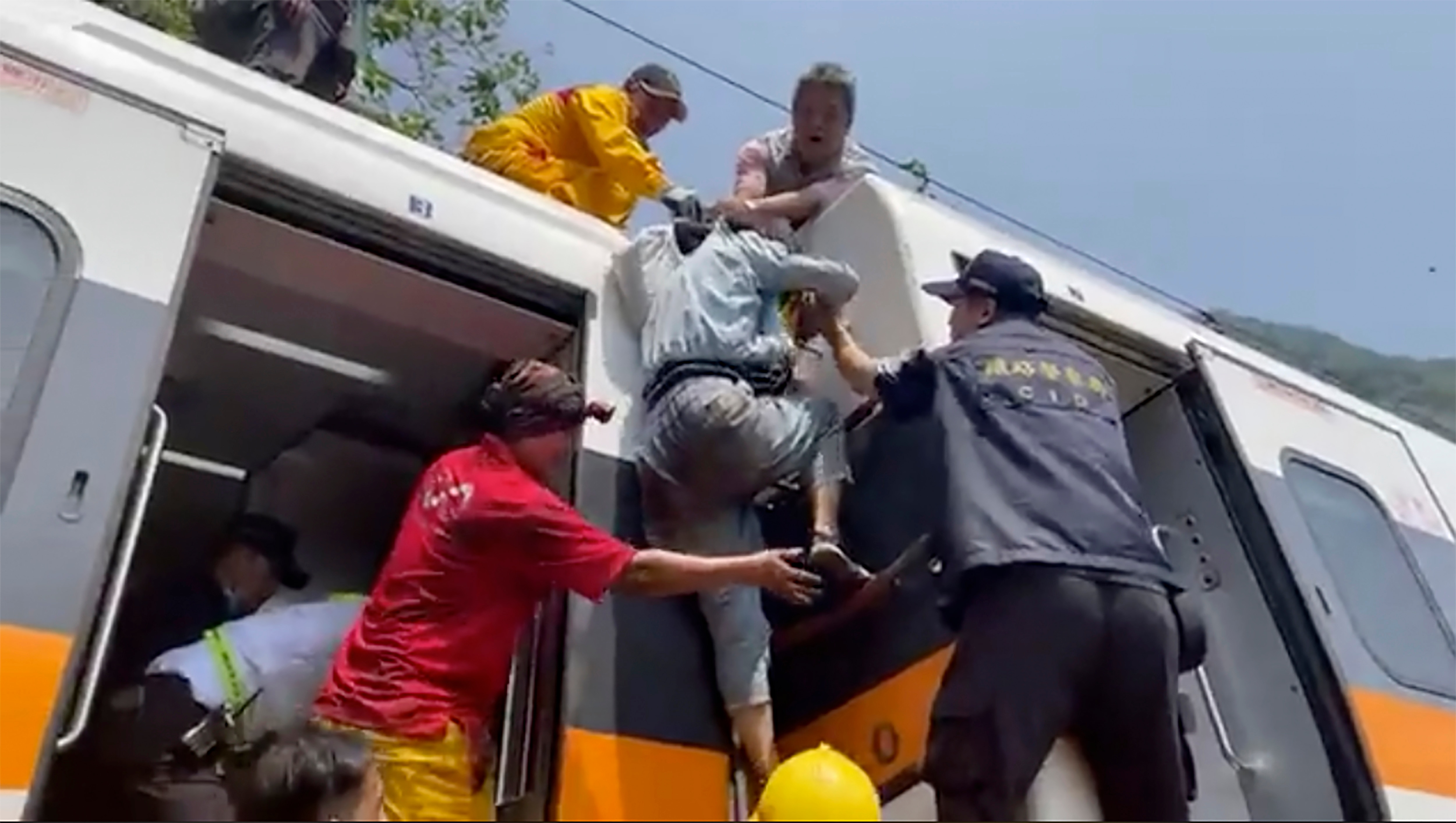 In this image from a video released by hsnews.com.tw, a passenger is helped to climb out of a derailed train in Hualien County on 2 April, 2021. 