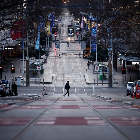 A person crosses a quiet Bourke Street in Melbourne, Friday.