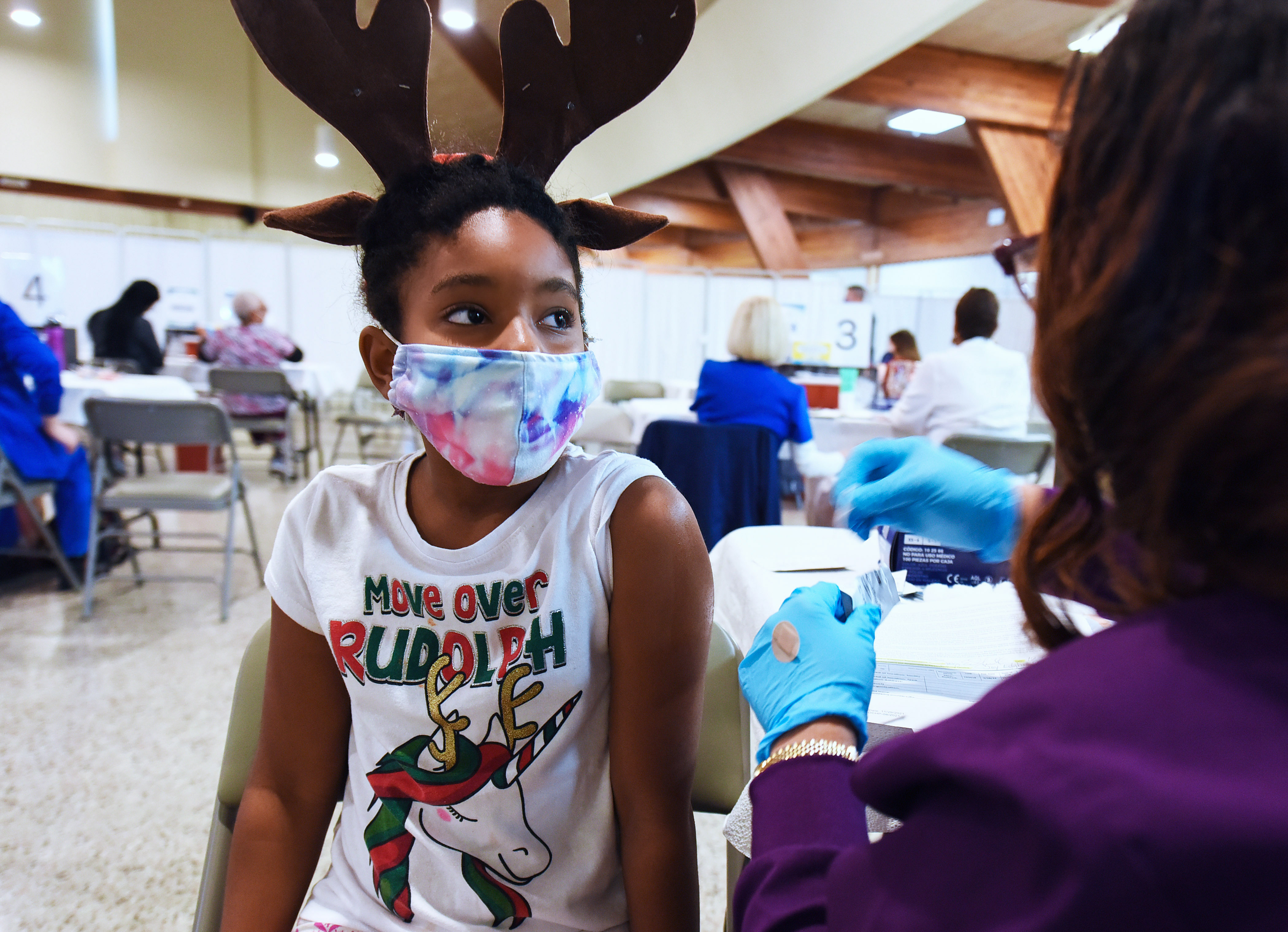 A health worker prepares to vaccinate a girl at the Sanford Civic Center in the US, where children as young as five are already being vaccinated.