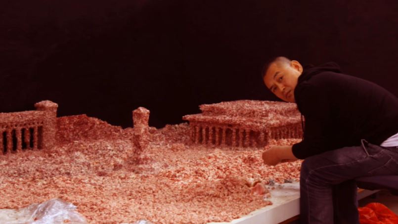 Guo Jian making a diorama of Tiananmen Square using raw pork mince in 2014.