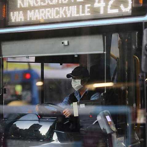 A bus driver wears a face mask while driving a public bus in Sydney. 