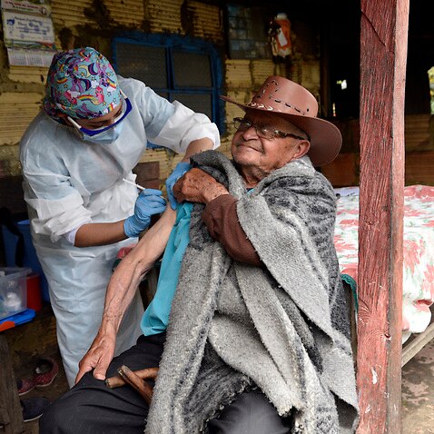 A nursing assistant gives a shot to an elderly man during a door-to-door vaccination campaign in rural areas of Bogota.