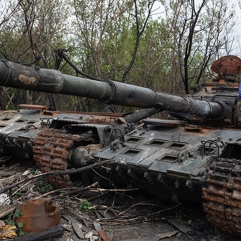 A girl stands on the tower of a destroyed Russian tank near Makariv village, Kyiv region.