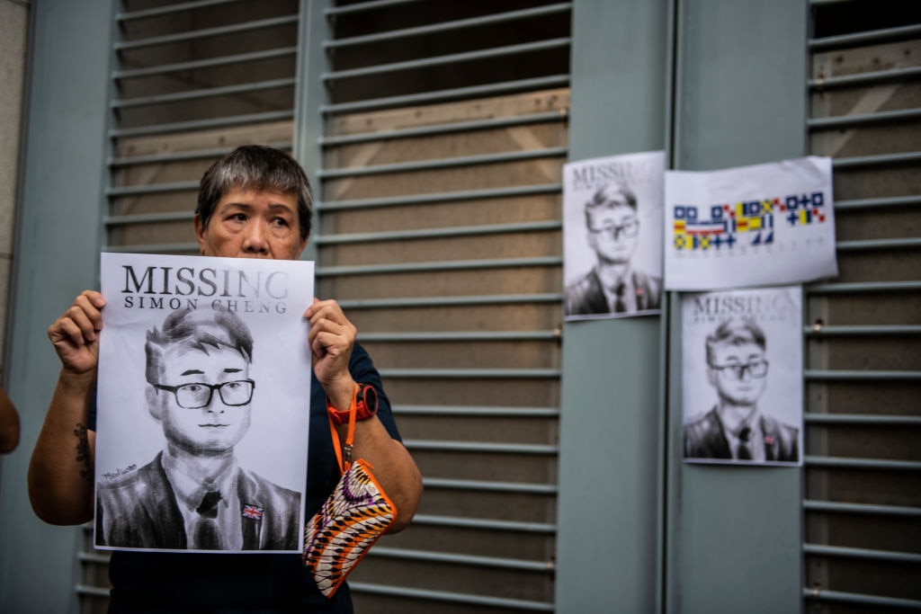 A woman holds up a Badiucao poster of Simon Cheng, the British consulate worker who was detained in mainland China.