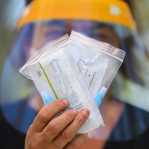 Maria Scafi, the site lead at the Rapid Antigen Test Kit Distribution centre poses for a photograph with a Rapid Antigen Test Kit at the Sunshine West Community Centre in Melbourne, Thursday, January 20, 2022. (AAP Image/James Ross) NO ARCHIVING