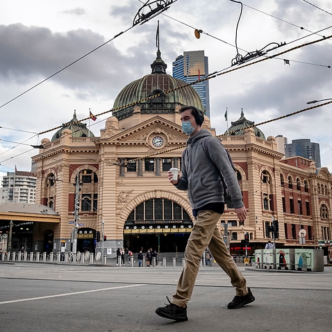 People walk past Flinders station in Melbourne on Monday, 9 August, 2021, amid a COVID-19 lockdown.