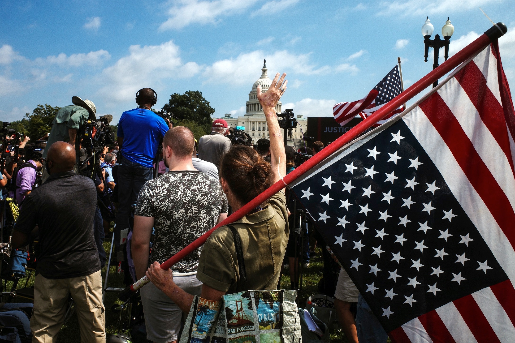 A woman cheers as she holds an upside down US flag during the 'Justice for J6' protest, on Capitol Hill.